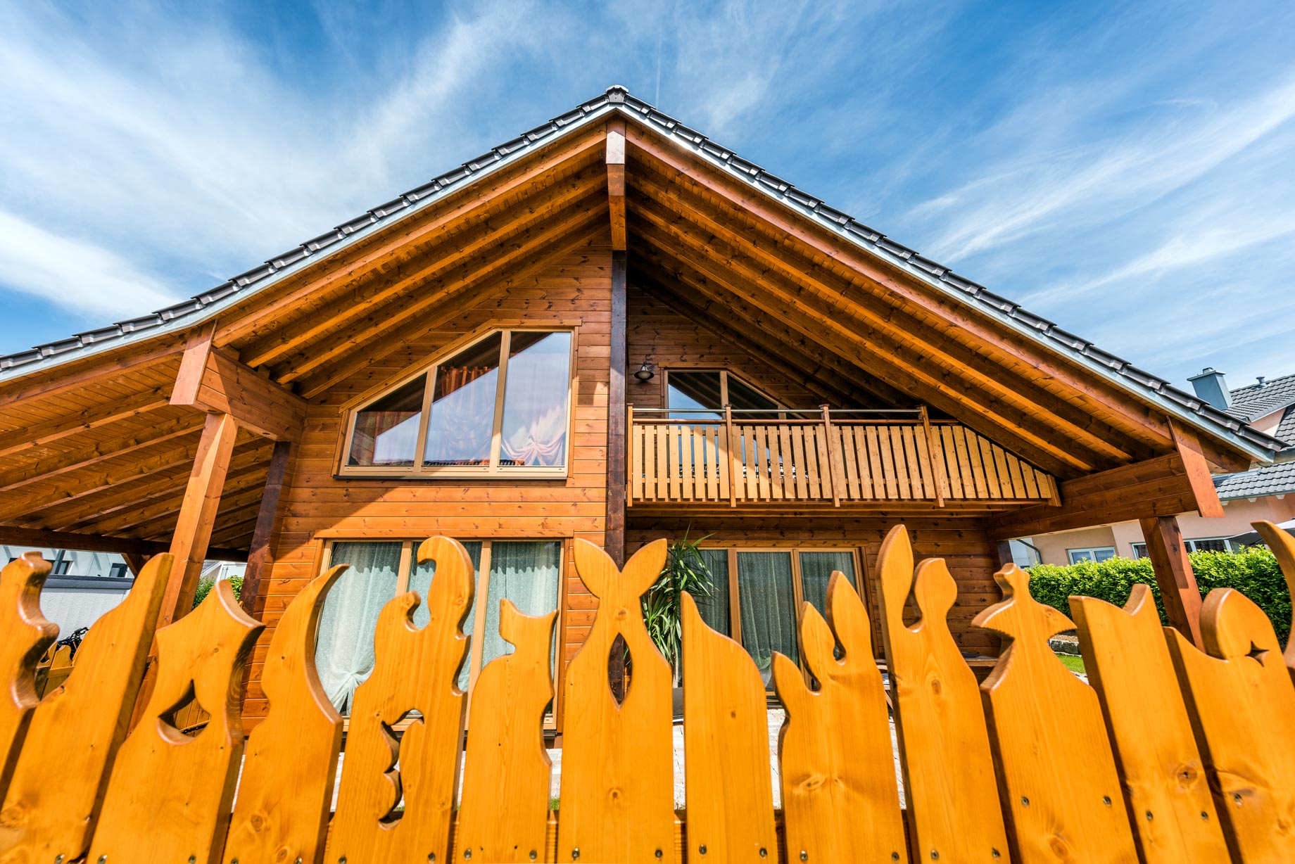 Massivholzhaus im modernen Landhausstil mit klarer Formensprache, massiver Holzfassade und großzügigen Fensterflächen.