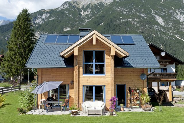 Helles modernes Blockhaus mit Erker und im rauen Alpenklima.